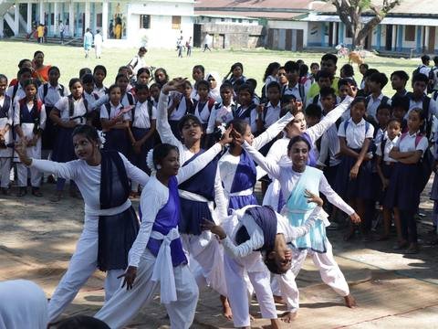 Students performing a group dance in blue and white costume