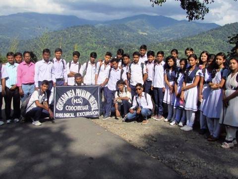 Students and teachers with the school banner in the hills